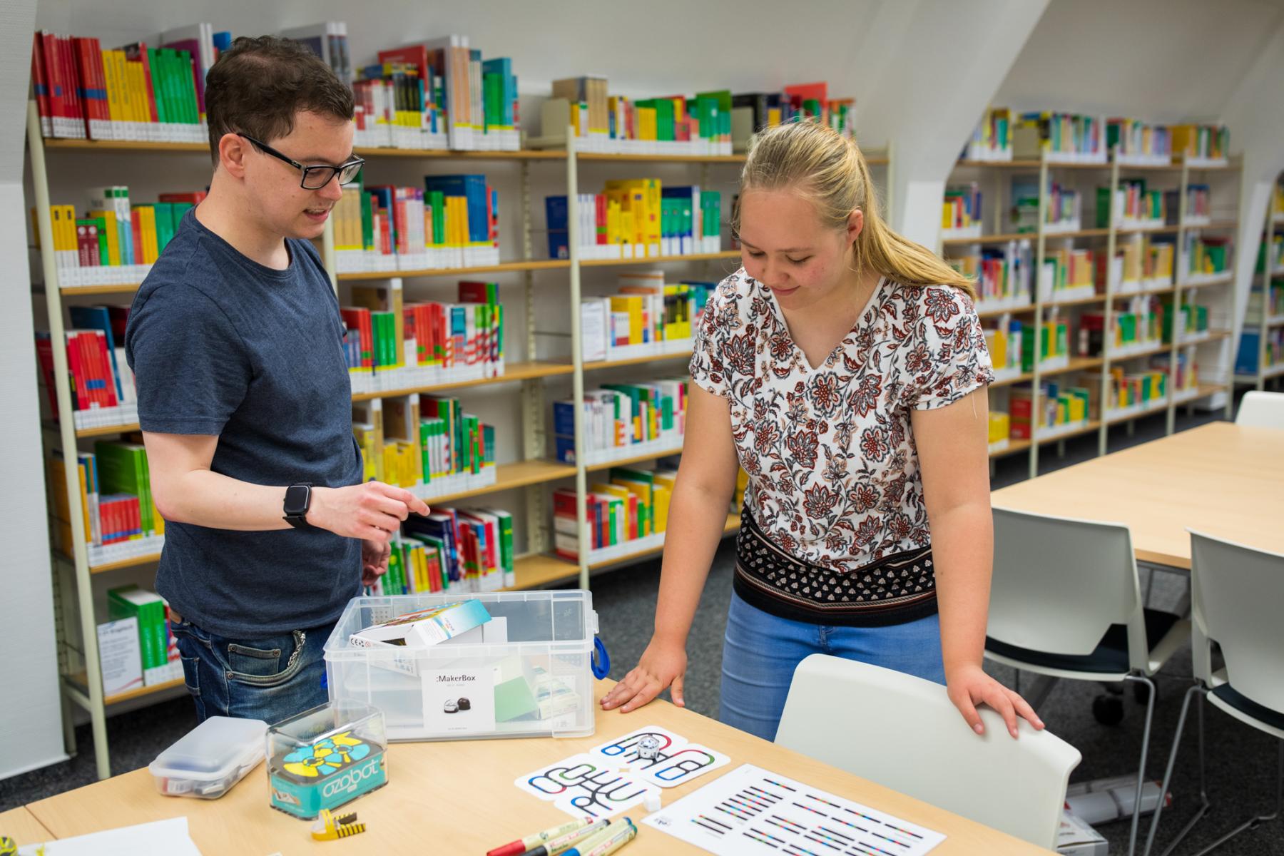 Zwei Personen in einer Bibliothek