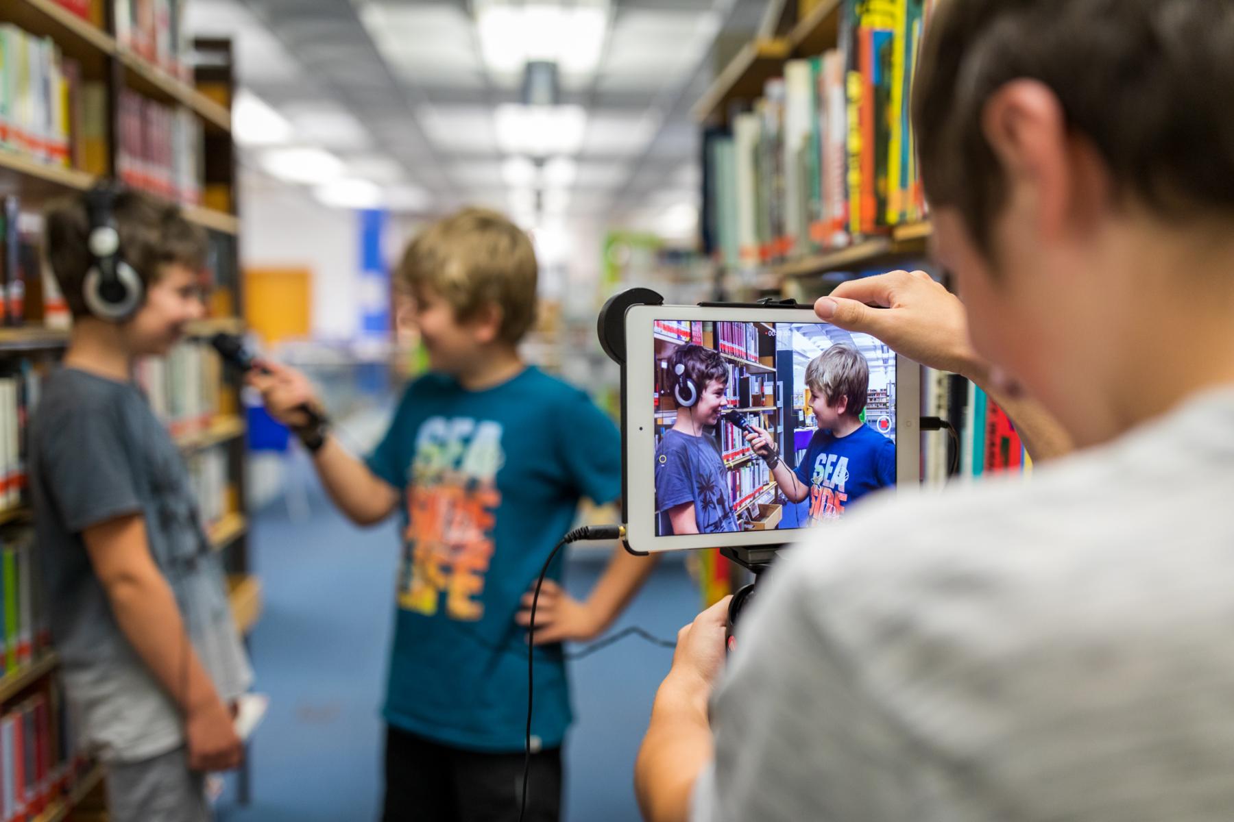 Jugendlicher filmt Kinder mit dem Tablet