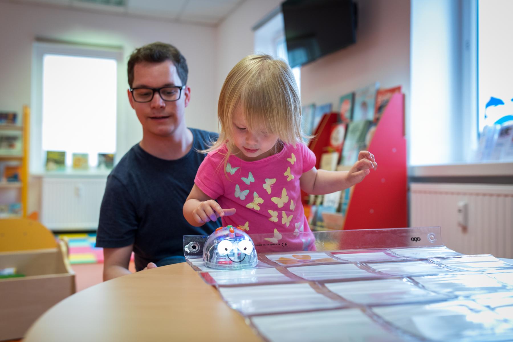 Kind und Medienpädagoge mit Blue-Bot