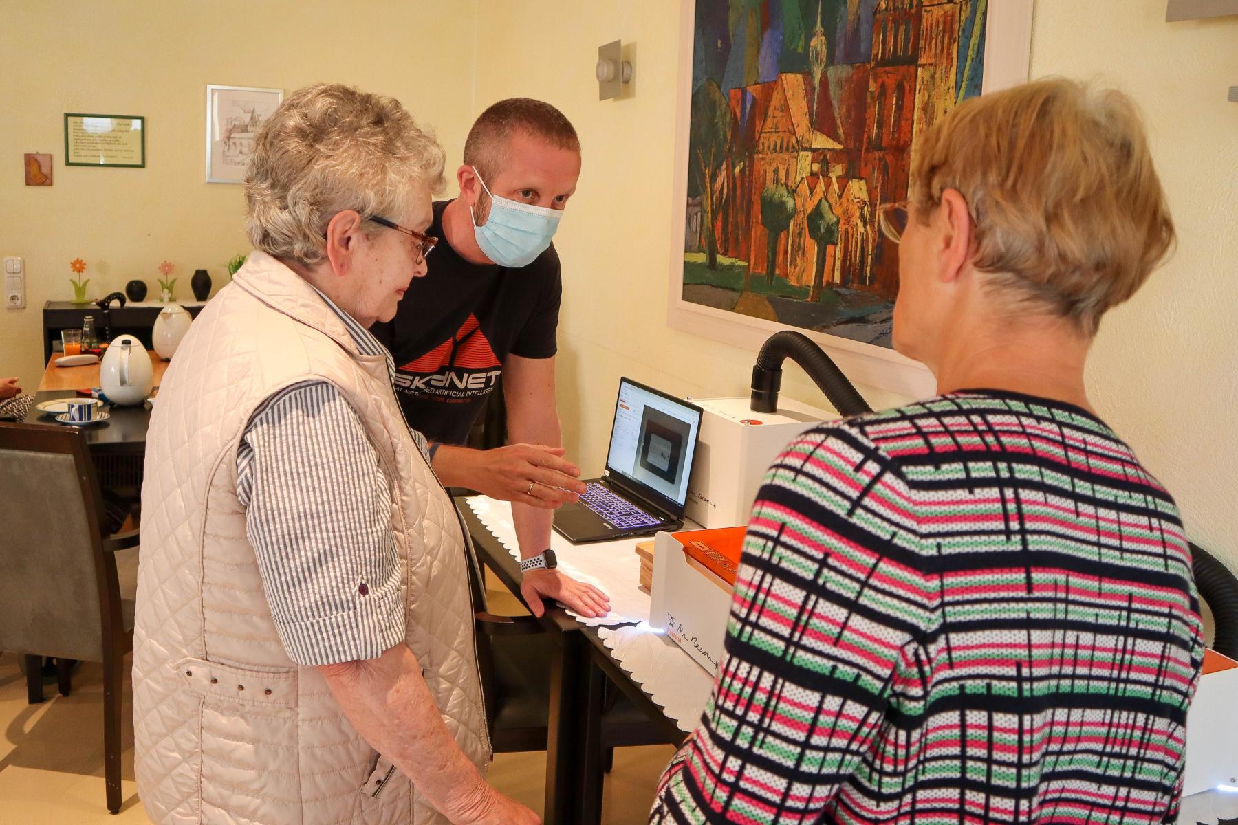 Besucher in der Stadtbibliothek Güstrow schauen sich ein digitales Angebot an