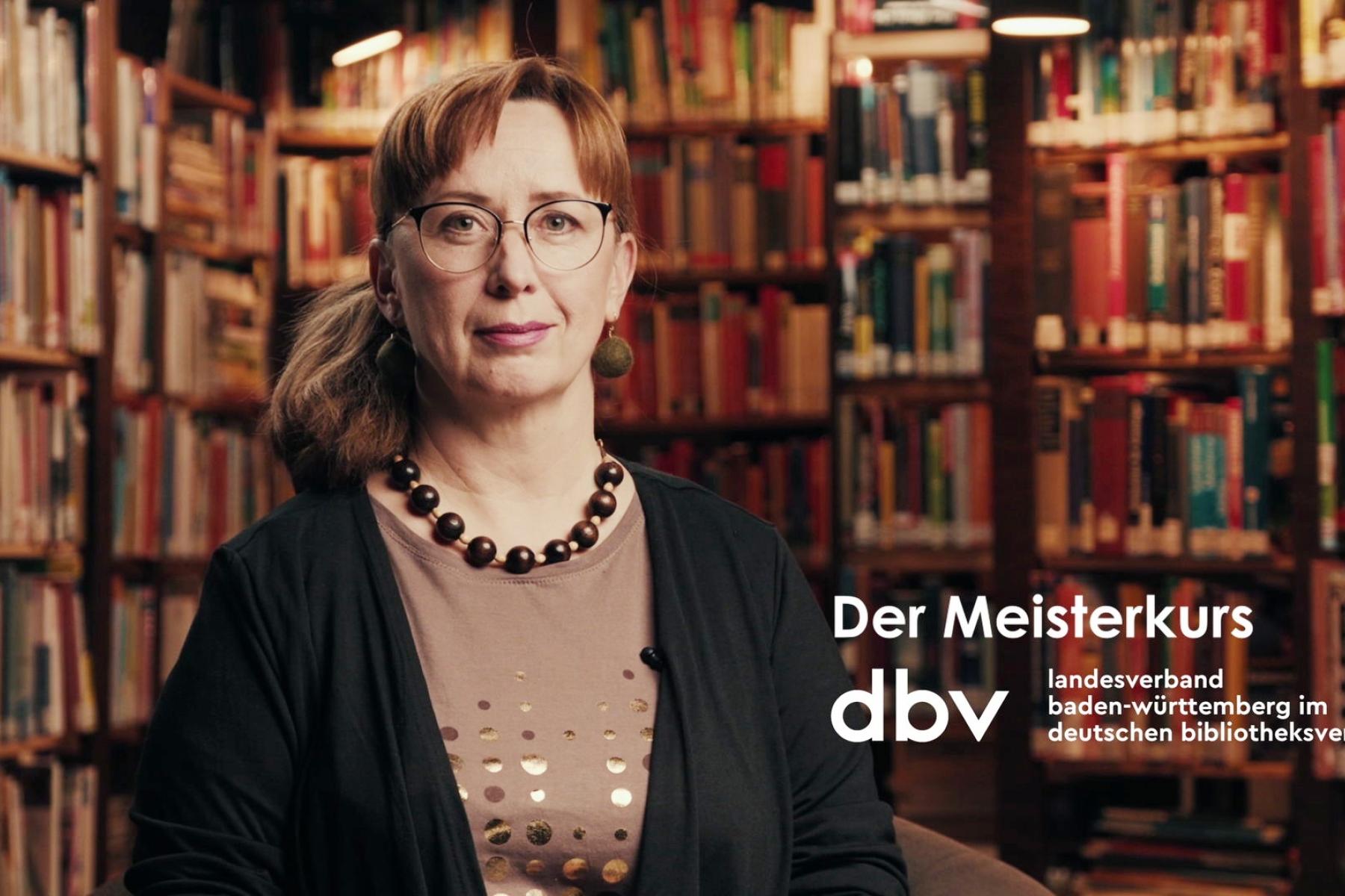 Videostill des Imagefilms, Bibliothekarin sitzt vor Büchern