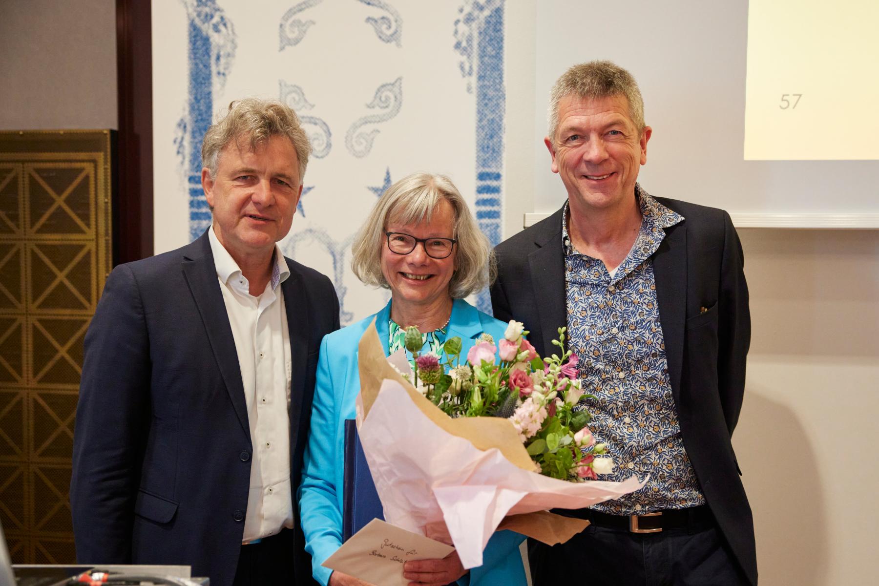 Drei Personen lächeln in die Kamere. Links Dr. Frank Mentrup, in der Mitte Barbara Schleihagen, sie hält einen Blumenstrauß in der Hand, rechts Volker Heller.