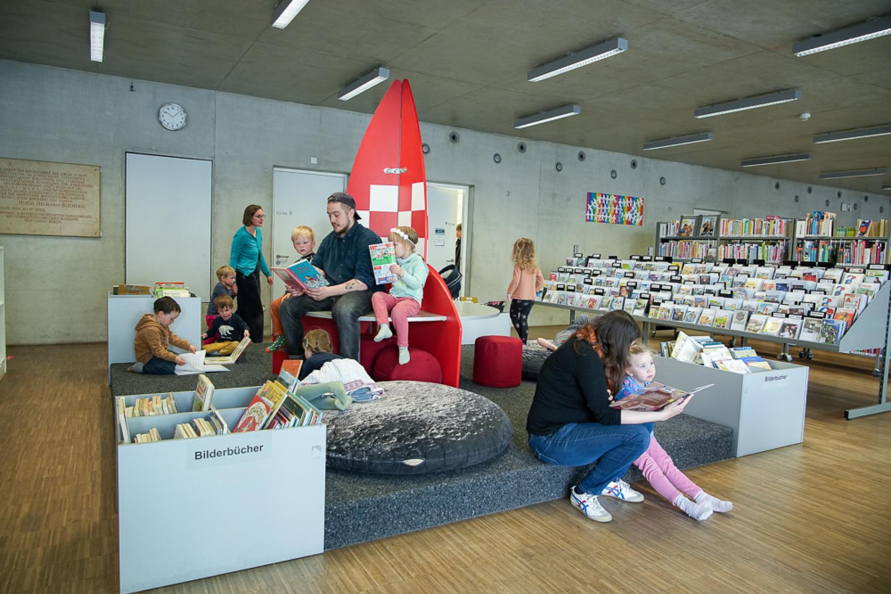 Kitagruppe in der Bibliothek wird von den Erzieherinnen vorgelesen.