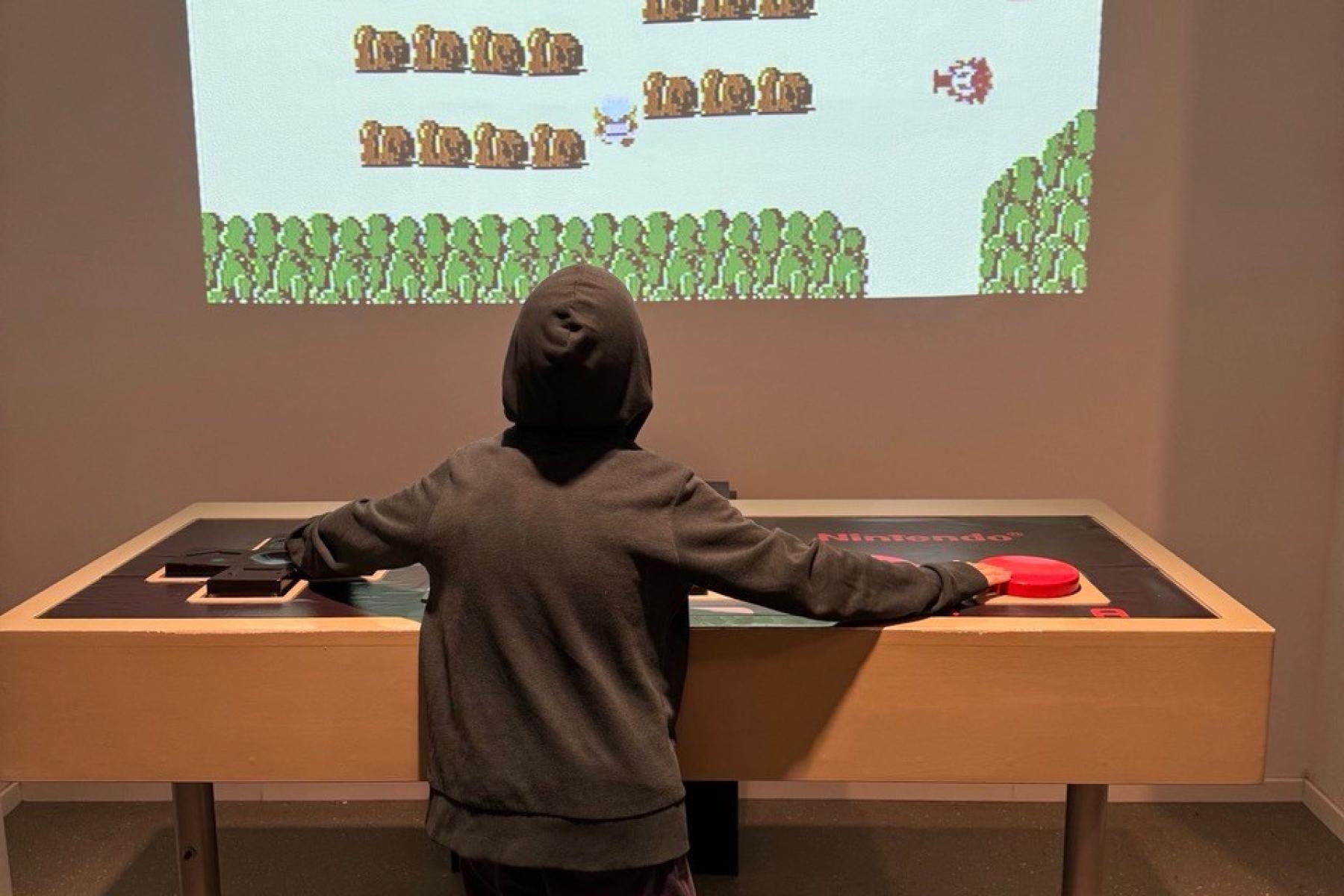 Kind vor einem gaming-Screen an der Wand