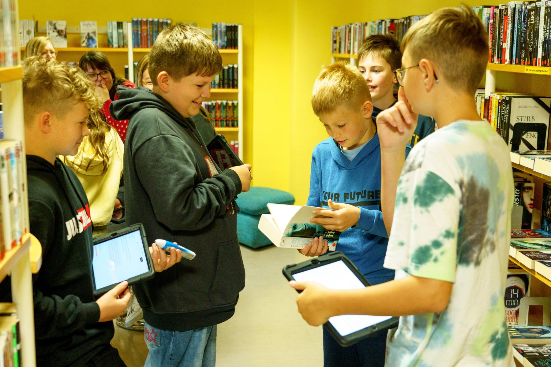 Eine Gruppe Jungen in der Bibliothek mit Tablets