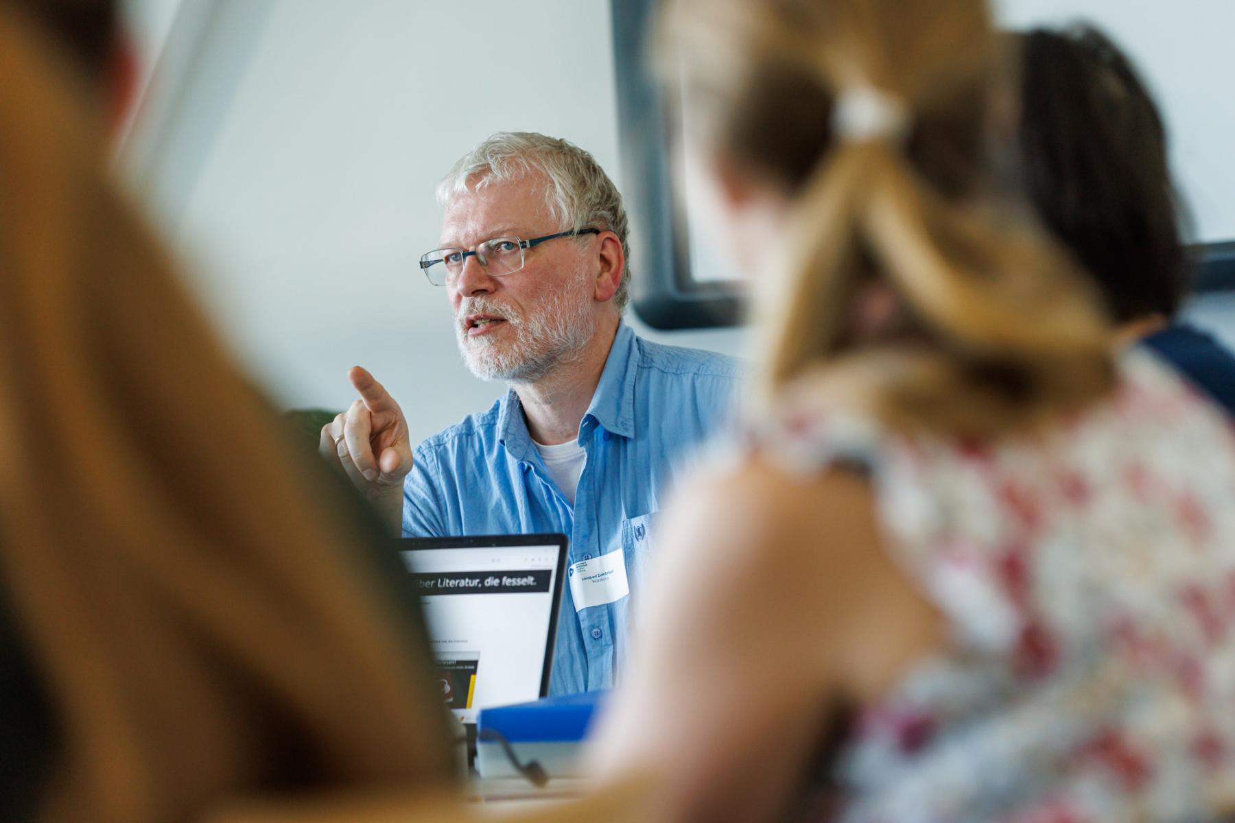 Workshopsitutaion, bei der ein Mann etwas erklärt.