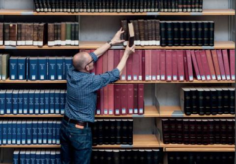 Eine Person in einer wissenschaftlichen Bibliothek