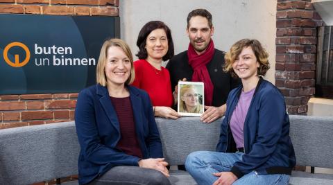 Foto der Autor*innen Brit Bentzen, Anna Berkhout, Anna-Lena Borchert, Nina Cöster und Immo Maus, die auf einem Sofa im Studio des magazins Butten un Binnen sitzen und in die Kamera lächeln.