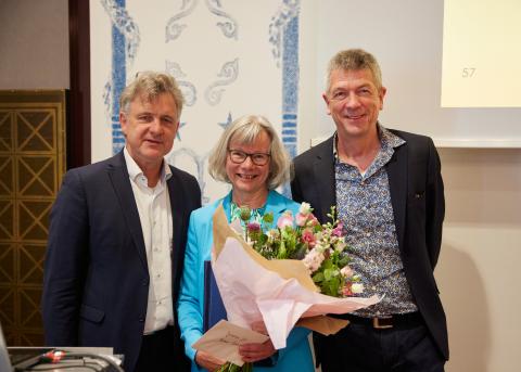 Drei Personen lächeln in die Kamere. Links Dr. Frank Mentrup, in der Mitte Barbara Schleihagen, sie hält einen Blumenstrauß in der Hand, rechts Volker Heller.