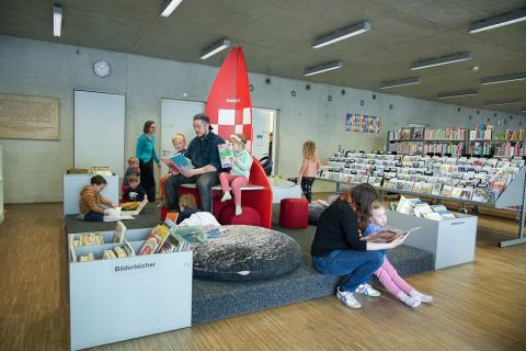 Kitagruppe in der Bibliothek wird von den Erzieherinnen vorgelesen.