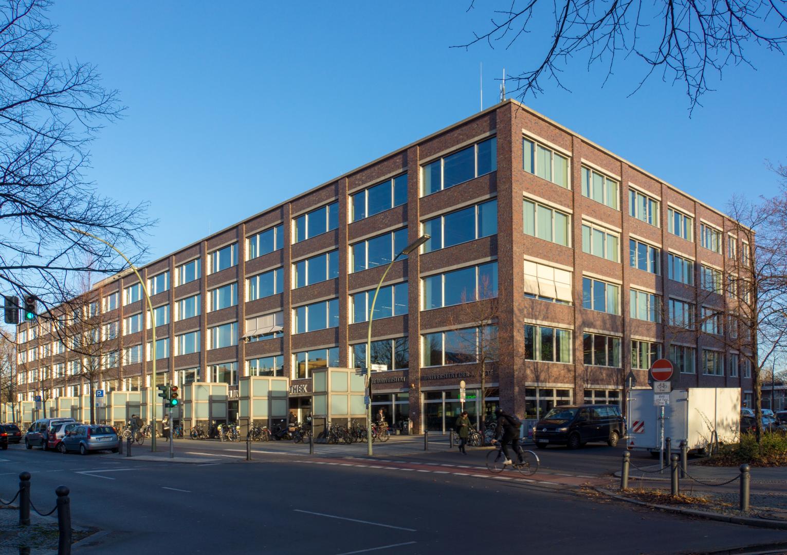 Außenansicht der Universitätsbibliotheken der TU Berlin und UdK Berlin am Tag, Blauer Himmel, Bäume ohne Blätter.
