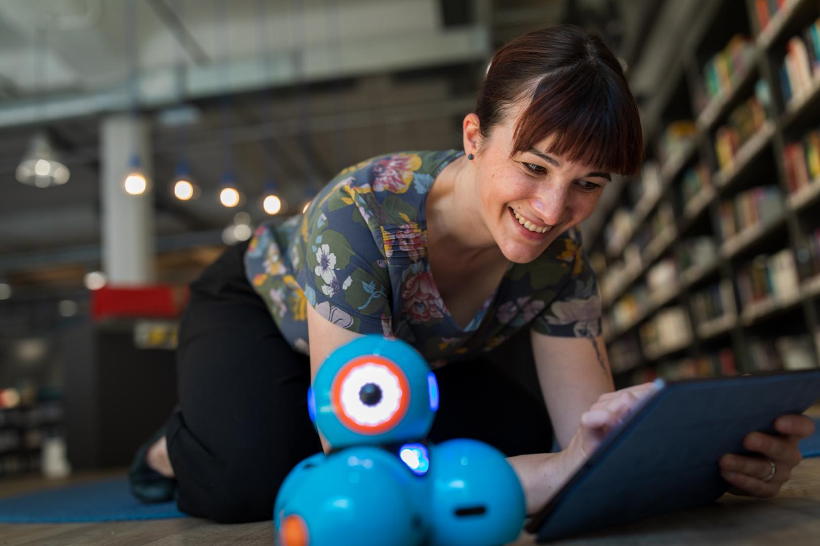 Bibliotheksmitarbeiterin programmiert einen Roboter
