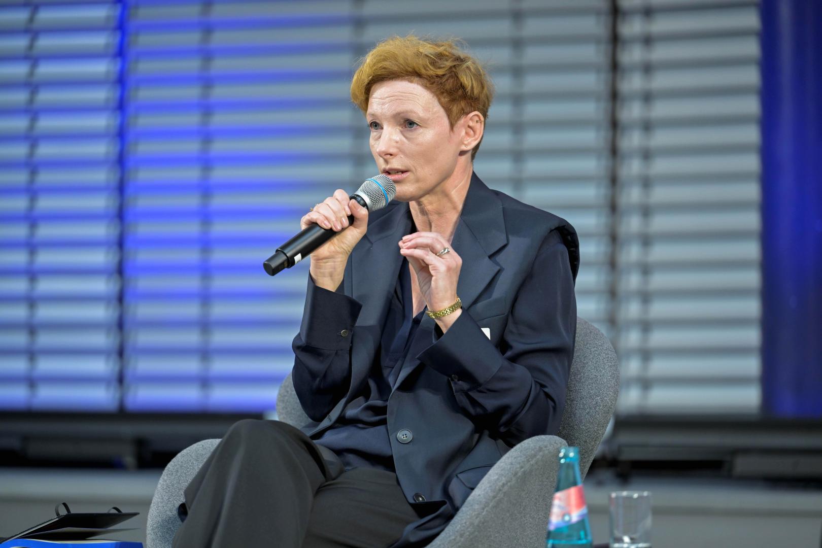 Eine Frau spricht in ein Mikrofon.