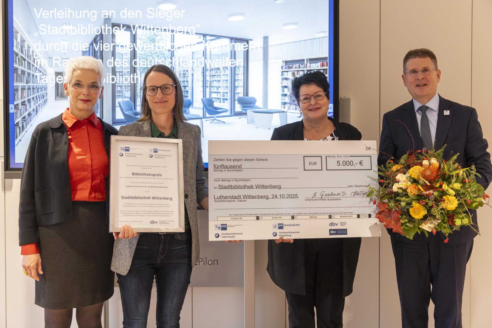 Preisträger mit Check und Blumen