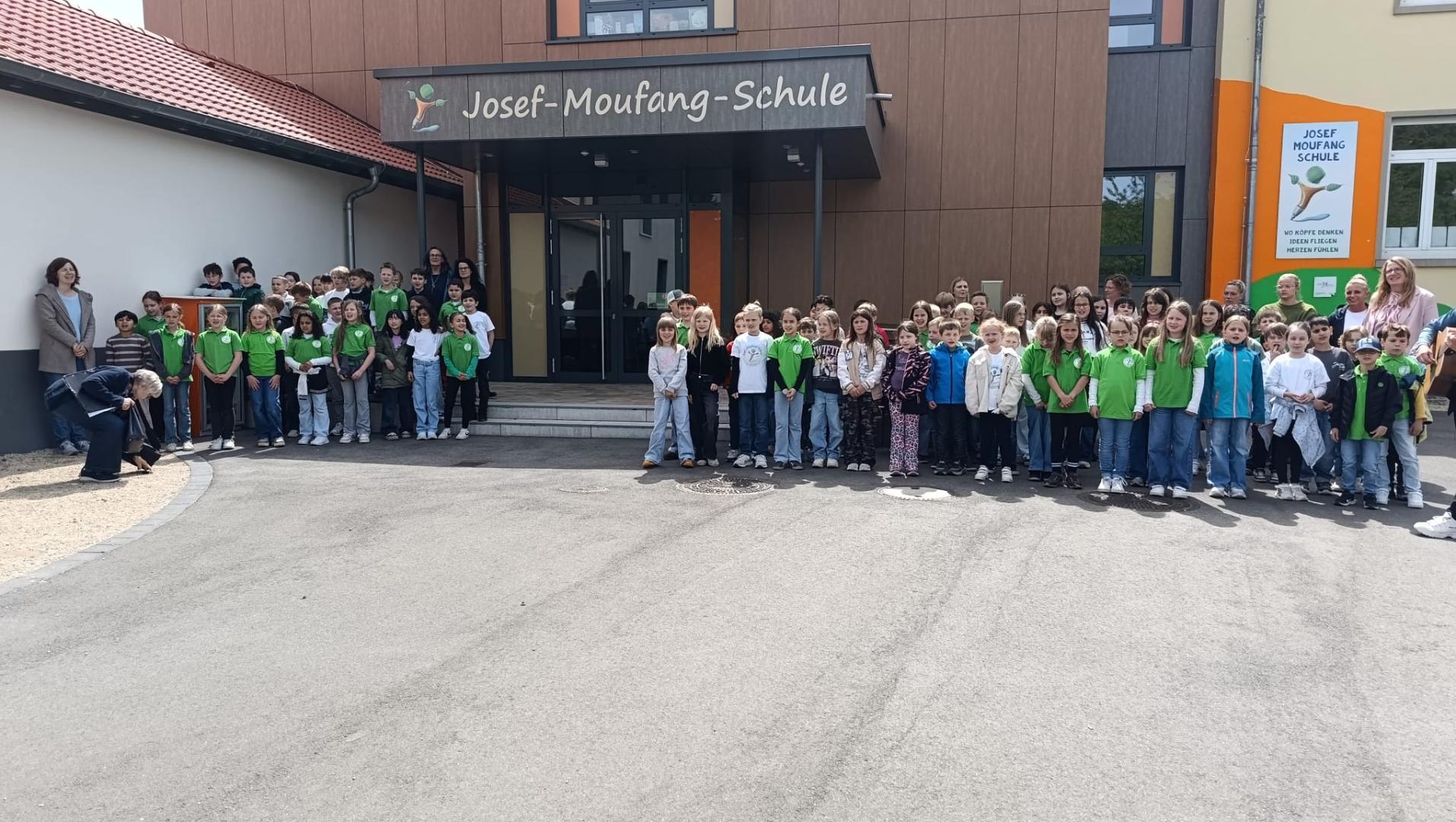 Kinder stehen vor der Schule.