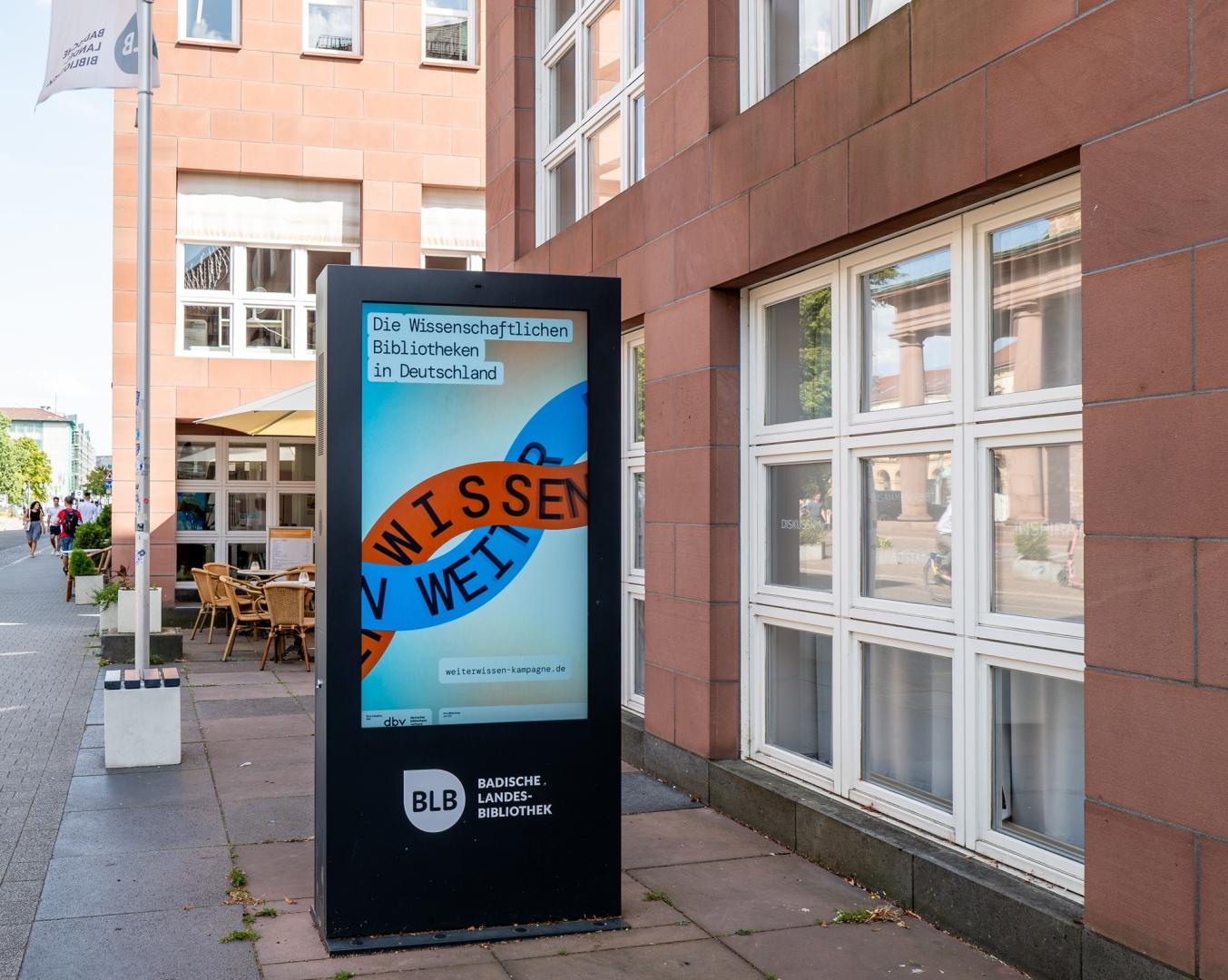 Leuchtkasten mit Weiter Wissen-Plakat