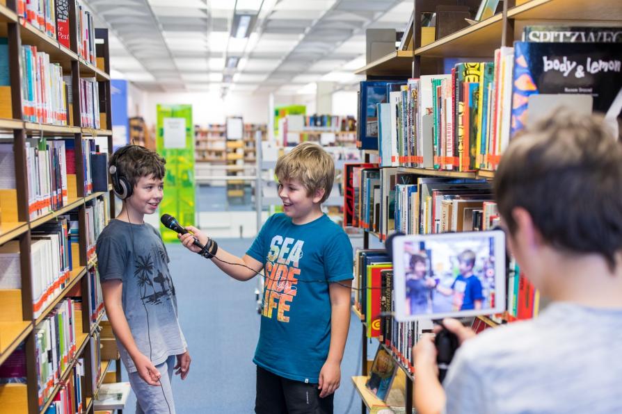 Kinder drehen Film in der Bibliothek