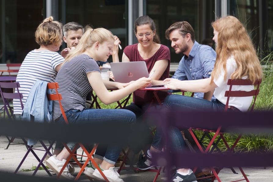 Personengruppe am Tisch im Außenbereich der AGB