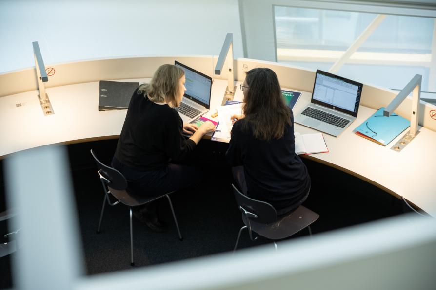 Zwei Frauen arbeiten in der Bibliothek 