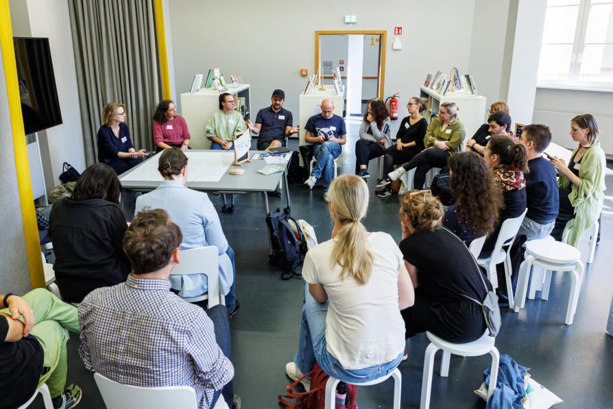 Eine Workshopgruppe sitzt zusammen um einen Tisch